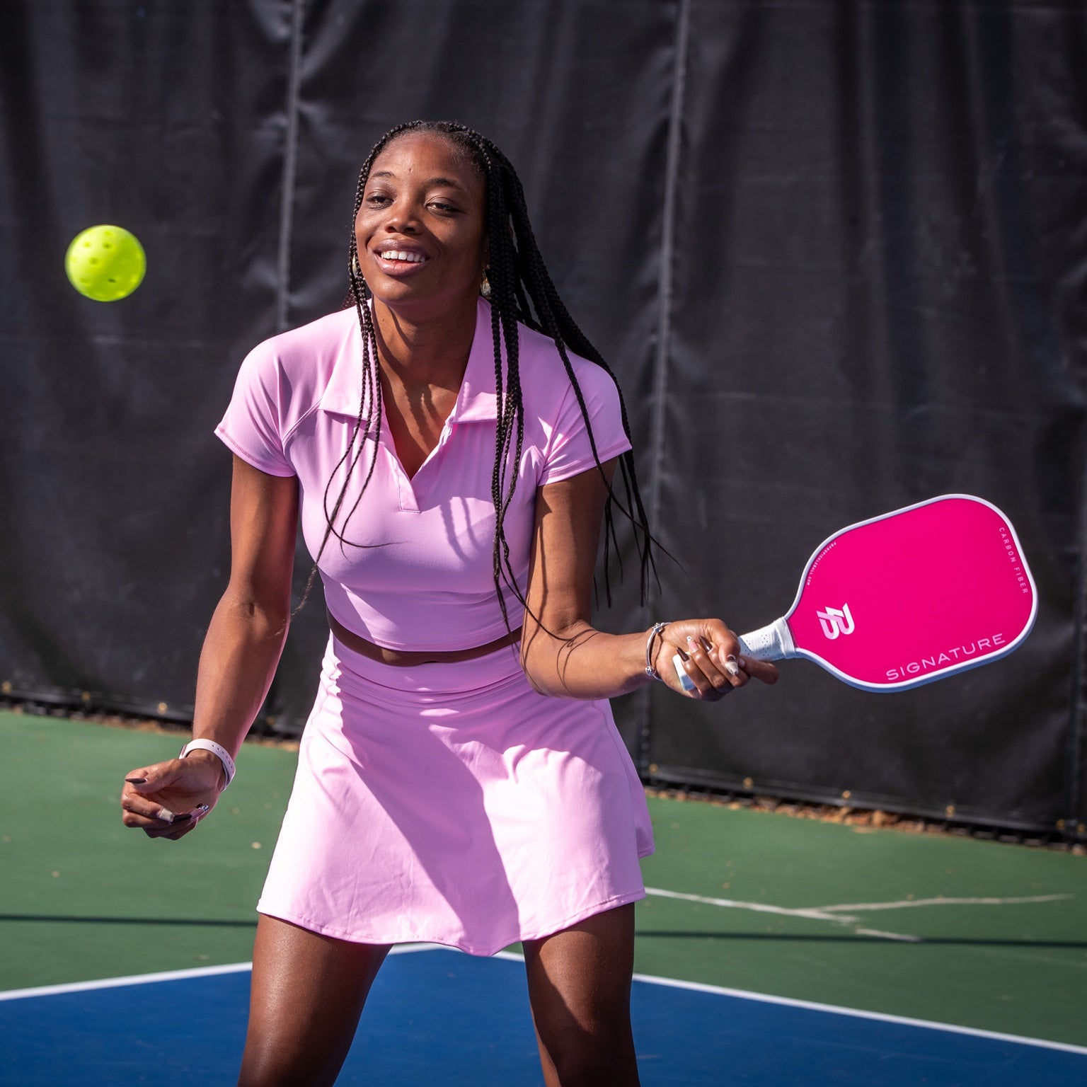 Player in pink with a pink PBPRO Signature pickleball paddle